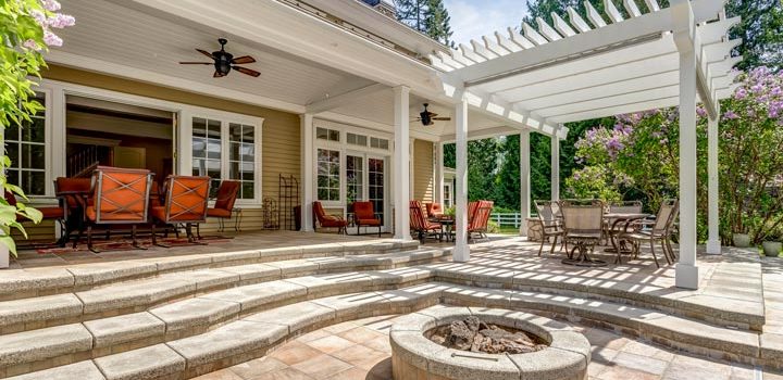 House grounds with a wooden pergola and a stone fireplace are ideal for gatherings.